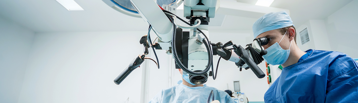 A physician looks through equipment while he is performing a procedure or surgery.